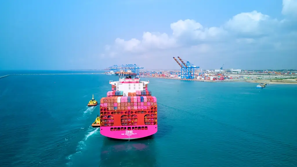 Contenedores magenta de ONE apilados en terminal portuaria