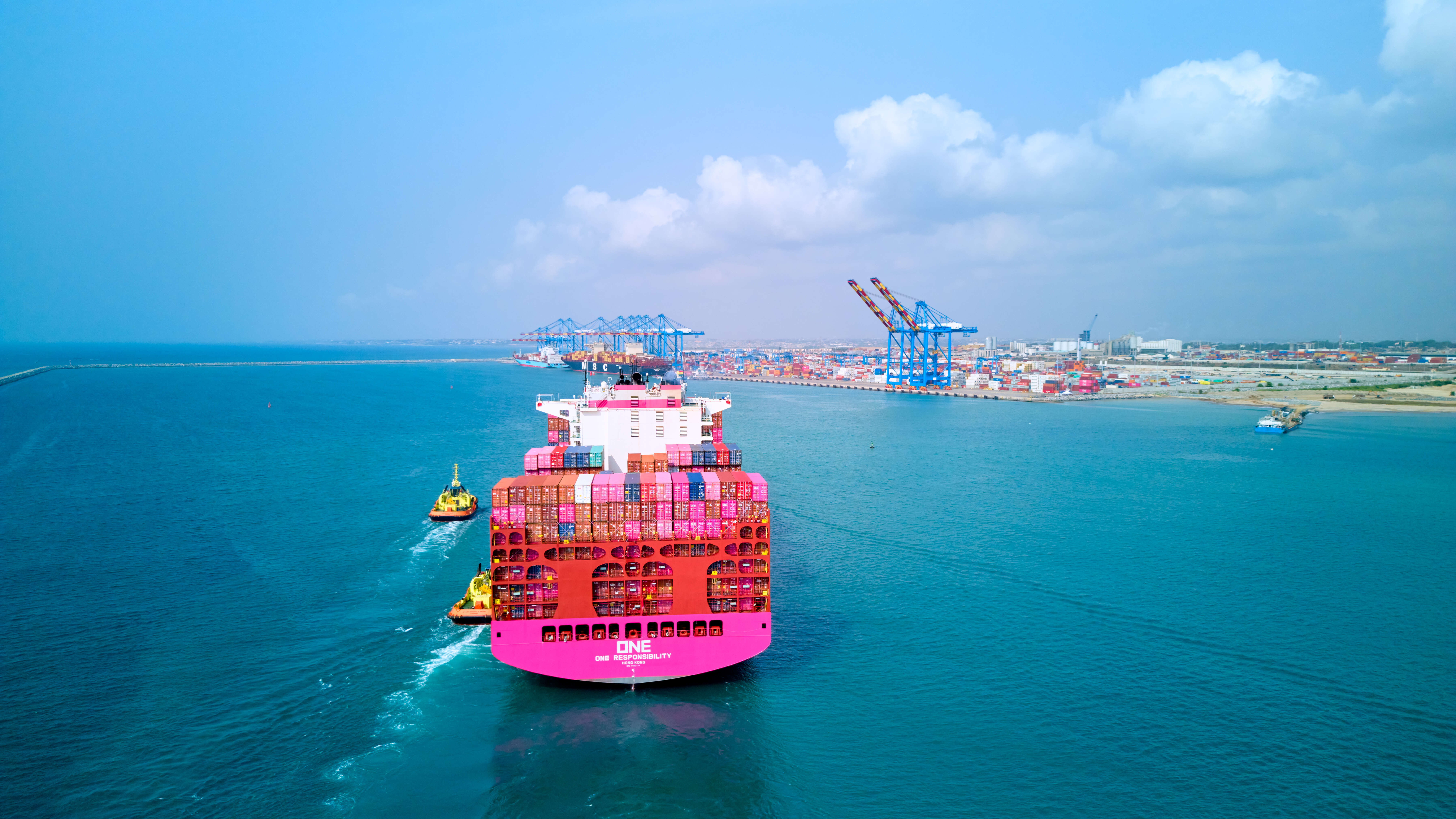 Contenedores magenta de ONE apilados en terminal portuaria
